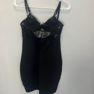 Black mini dress. With adjustable straps in the top and back of the dress.